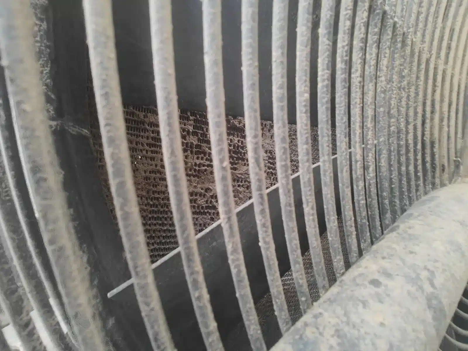 Detalle de radiador de maquinaria de obra pública con suciedad severa