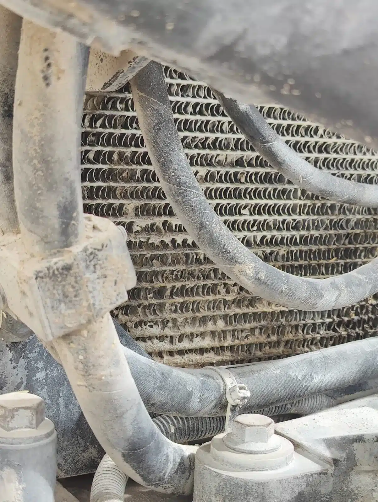 Suciedad entre paquetes de refrigeración en maquinaria de obra pública